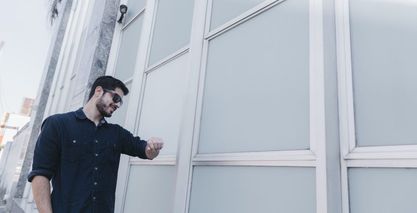 smiling-man-looking-wristwatch-street (1)